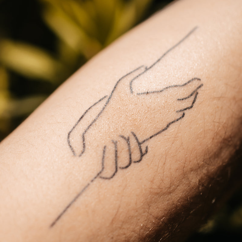 Haltende Hände Tattoo